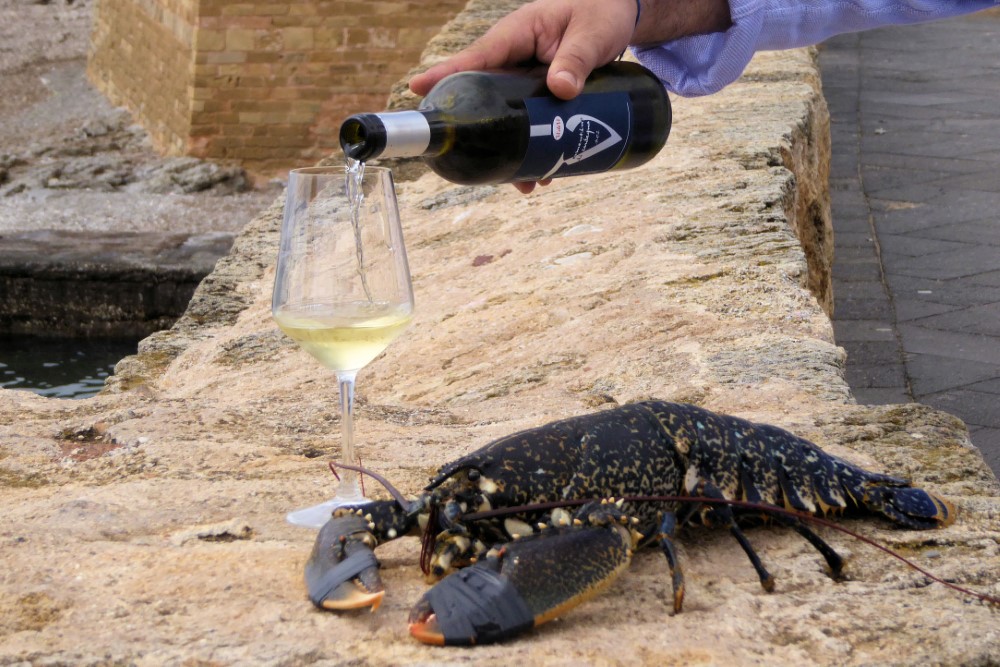 Gastronomía en el paseo costanero de Alghero, Cerdeña, Italia