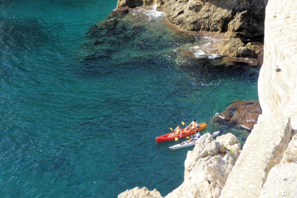 Kayaks en el mar al pié de la muralla de la Ciudad de Dubrovnik, Croacia