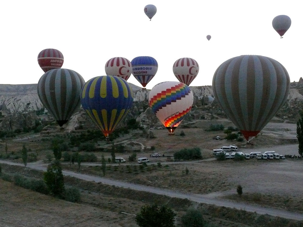 Balões de ar quente sobrevoando Göreme, Capadócia, Turquia.